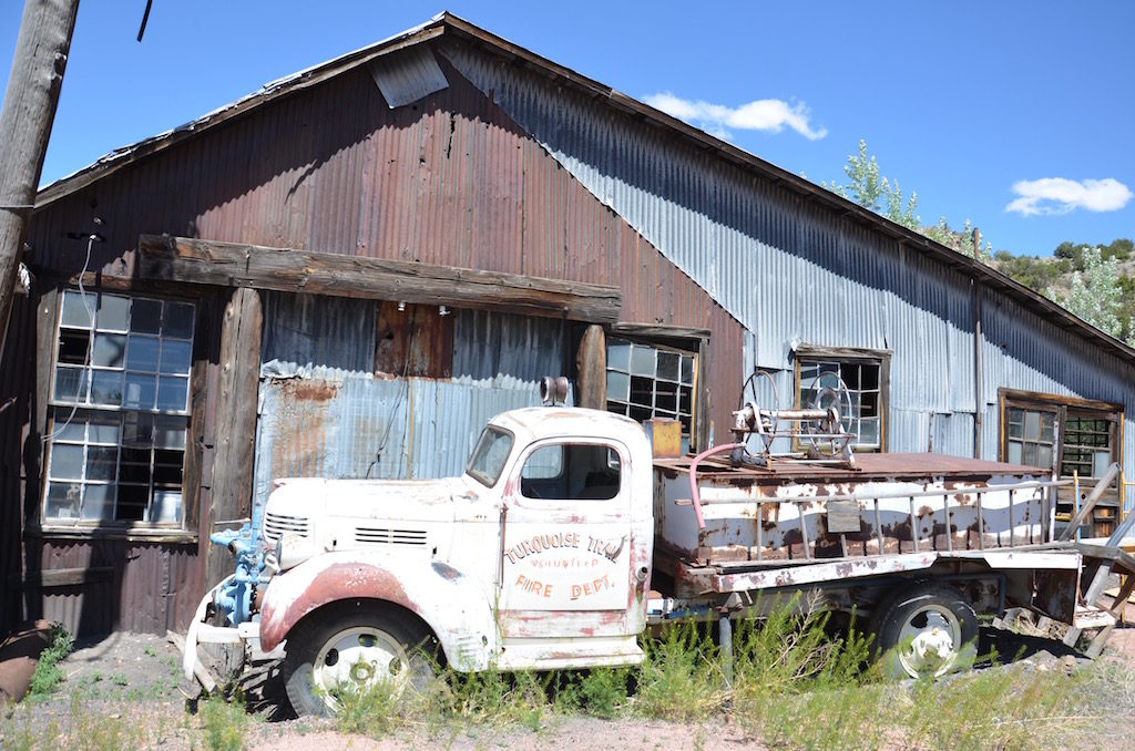 A few old rusting antique cars and trucks.